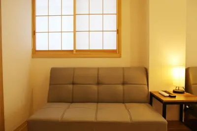 a couch in a living room with a window at M208 Easy access to Ikebukuro Red Leaves ,Golden Ginkgo in Tokyo