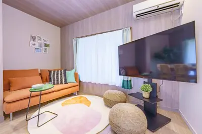 a living room with a couch and a flat screen tv at Enjoy Meguro House in Tokyo
