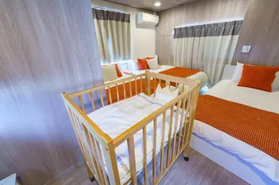 a small room with two beds and a crib at Enjoy Meguro House in Tokyo