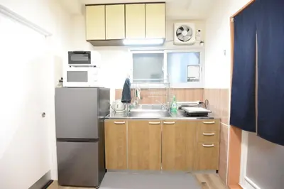 a small kitchen with a sink and a refrigerator at SleepTokyo in Tokyo