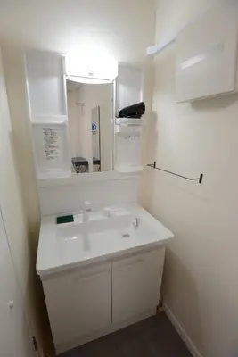 a white bathroom with a sink and a mirror at SleepTokyo in Tokyo