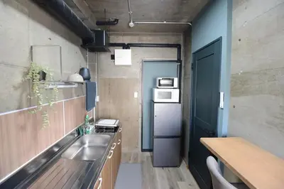 a small kitchen with a sink and a refrigerator at SleepTokyo in Tokyo
