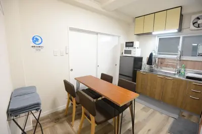 a small kitchen with a wooden table and chairs at SleepTokyo in Tokyo