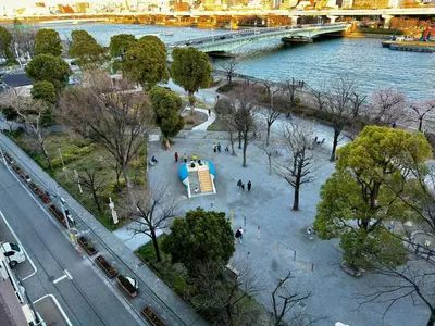people walking in a park next to a river at \u30a8\u30d3\u30b9\u30d3\u30eb8\u968eStayCreek in Tokyo