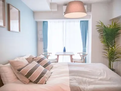 a bedroom with a bed with pillows and a table at Triphome Sugamo Otsuka 2025 New 7 mins 2 stations in Tokyo