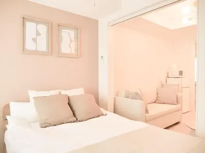 a white bedroom with a bed and a chair at Triphome Sugamo Otsuka 2025 New 7 mins 2 stations in Tokyo