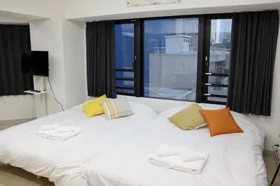 a large white bed in a room with windows at \u30d5\u30a7\u30a4\u30b9\u864e\u30ce\u95808\u968e in Tokyo