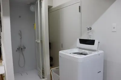 a white bathroom with a washing machine and a shower at \u30d5\u30a7\u30a4\u30b9\u864e\u30ce\u95808\u968e in Tokyo