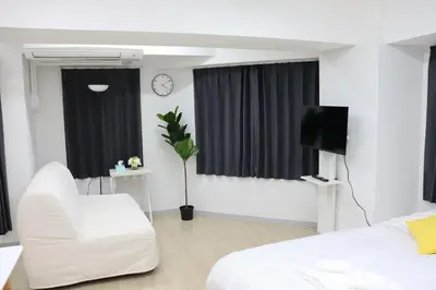 a white living room with a white couch and a tv at \u30d5\u30a7\u30a4\u30b9\u864e\u30ce\u95808\u968e in Tokyo
