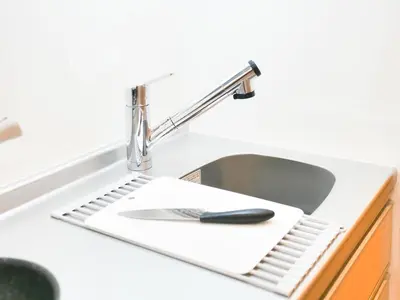 a kitchen sink with a black spoon on a white holder at Triphome Otsuka Sugamo in Tokyo