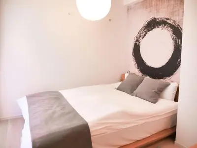 a bedroom with a bed with a mirror on the wall at Triphome Otsuka Sugamo in Tokyo