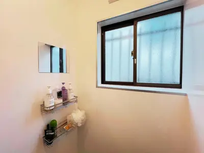 a bathroom with a window and a shelf with toiletries at Tokyo Nukumori Lodge in Tokyo