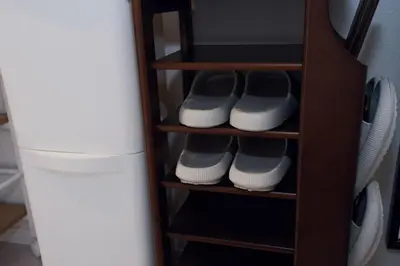 a shelf with pairs of shoes and a refrigerator at Taito City Negishi 2Ldk-TT0323 in Tokyo