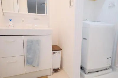 a white kitchen with a sink and a refrigerator at Taito City Negishi 2Ldk-TT0323 in Tokyo
