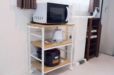 a microwave on a shelf next to a refrigerator at Taito City Negishi 2Ldk-TT0323 in Tokyo