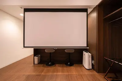 a large screen in a room with two stools at Cava House - Vacation STAY 07286v in Tokyo