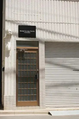 a building with a garage door with a sign on it at Takaoka Building - Vacation STAY 10286v in Tokyo