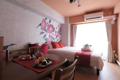 a bedroom with a bed and a table with a tray of food at Shinjuku Camellia Nest in Tokyo