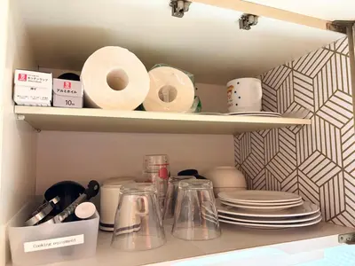 a cupboard with plates and dishes in a kitchen at Shinjuku Camellia Nest in Tokyo