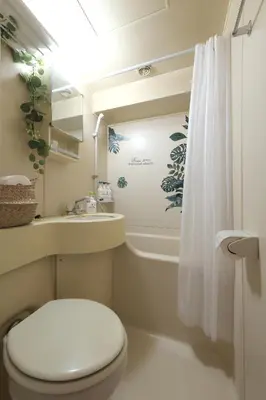a bathroom with a toilet and a sink and a shower at Shinjuku Camellia Nest in Tokyo