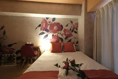 a bedroom with a bed with a flower mural on the wall at Shinjuku Camellia Nest in Tokyo