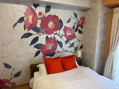 a bedroom with a flower mural on the wall at Shinjuku Camellia Nest in Tokyo
