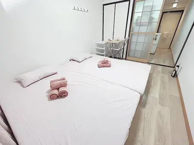 a white bed with two pink towels on it at Tokyo Stay West Sugamo #104 in Tokyo