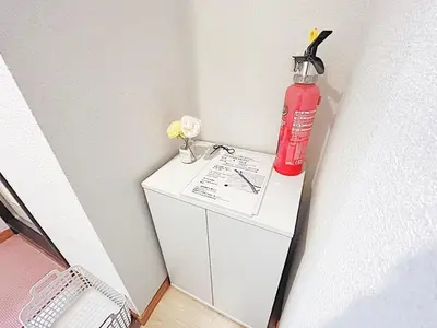 a red fire extinguisher on top of a white cabinet at Tokyo Stay West Sugamo #105 in Tokyo