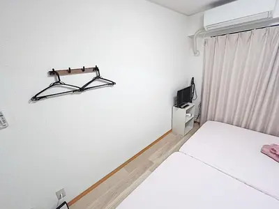 a white room with two beds and a tv at Tokyo Stay West Sugamo #105 in Tokyo