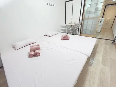 a large white bed with two pink towels on it at Tokyo Stay West Sugamo #105 in Tokyo