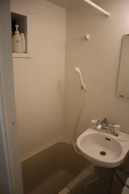 a white bathroom with a sink and a mirror at Tateishi House101 in Tokyo