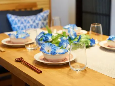 a table with plates and glasses and blue flowers on it at Yadoya Asakusa Asagao in Tokyo