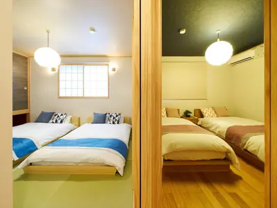 a bedroom with two beds and two mirrors at Yadoya Asakusa Asagao in Tokyo