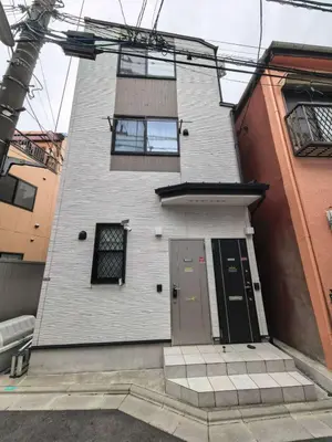 a tall white building with a door and windows at Tateishi House201 in Tokyo