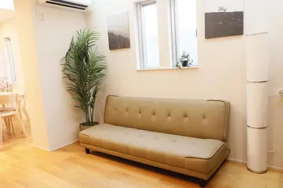 a couch in a living room with a plant at Dori Dori House Shinjuku1 in Tokyo