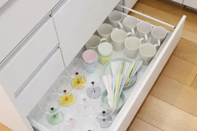 a white drawer filled with cups and utensils at Dori Dori House Shinjuku1 in Tokyo