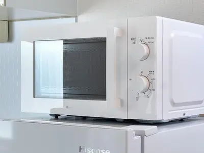 a white microwave oven on a shelf in a kitchen at \u30f4\u30a3\u30e9\u4ee3\u3005\u6728101 in Tokyo