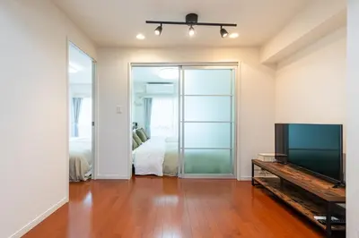 a living room with a television and a bedroom at \u30f4\u30a3\u30e9\u4ee3\u3005\u6728101 in Tokyo