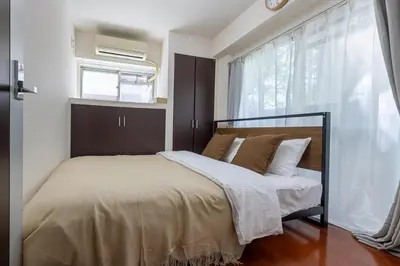 a bedroom with a bed and a window with a air conditioner at \u30f4\u30a3\u30e9\u4ee3\u3005\u6728101 in Tokyo