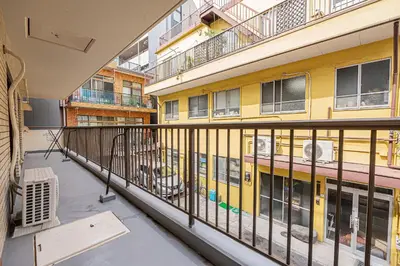 an empty balcony of a building with a yellow building at Mi-HOTEL SUGAMO in Tokyo