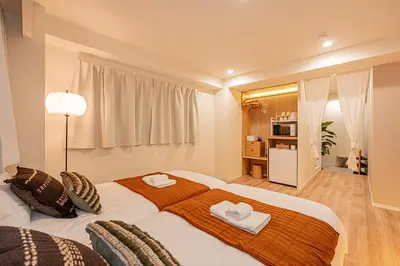 a bedroom with a large bed with two towels on it at Mi-HOTEL SUGAMO in Tokyo