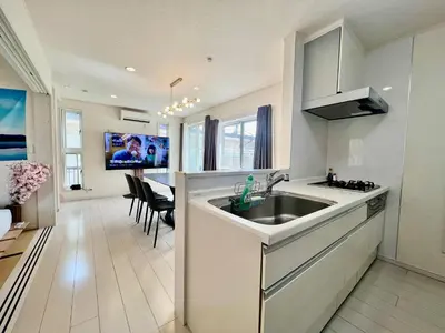 a kitchen with a sink and a living room at Near Ikebukuro! 2min to Kita Ikebukuro Large House in Tokyo
