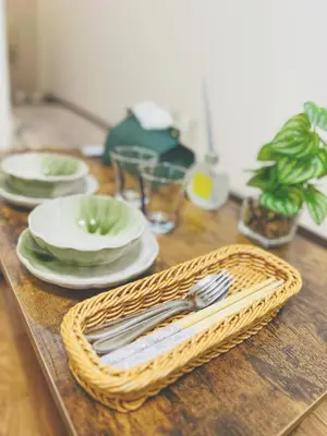a wooden table with plates and silverware on it at Shinjuku\u65b0\u5bbf1min in Tokyo