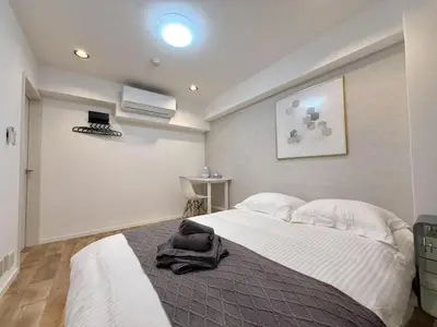 a bedroom with a large bed with white sheets at NEW & Spacious home in Tokyo