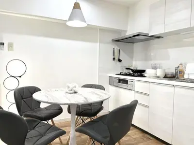 a white kitchen with a table and chairs at NEW & Spacious home in Tokyo