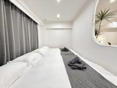 a bedroom with a white bed with a mirror at NEW & Spacious home in Tokyo