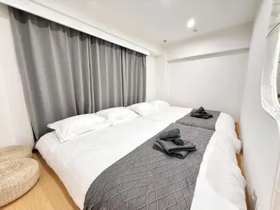 a bedroom with a large bed with towels on it at NEW & Spacious home in Tokyo