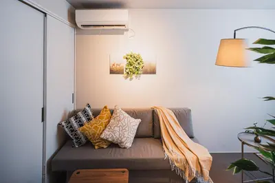 a living room with a couch with pillows at AT Shinjuku in Tokyo