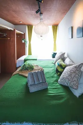 a large green bed with two pillows on it at AT Shinjuku in Tokyo