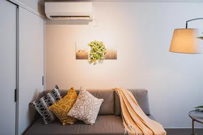 a living room with a couch with pillows at AT Shinjuku in Tokyo